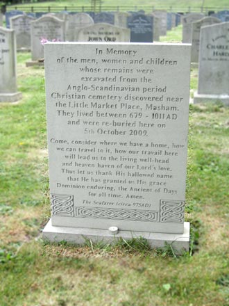 The gravestone in St Mary's churchyard commemorating the reburial of the bones discovered in Masham's lost cemetery, Masham, North Yorkshire